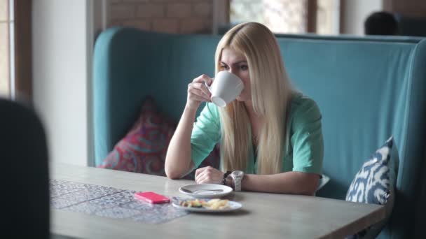 Jonge Blonde Vrouw Blauw Shirt Met Koffie Beker Met Behulp — Stockvideo