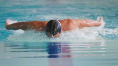 Genç adam havuzda yüzüyor..