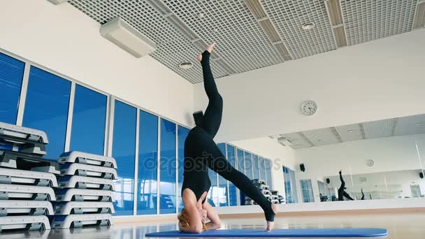 Femme en sportswear noir pratiquant le yoga — Video