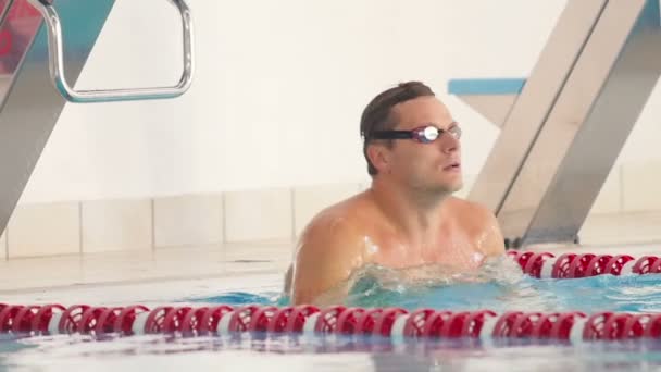Junger Mann schwimmt in Pool. — Stockvideo
