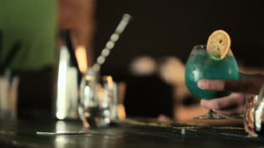 Mavi kokteyl tutan eller