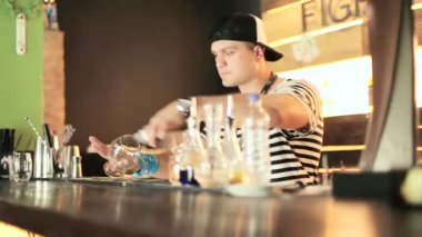 çizgili gömlekli genç yakışıklı barmen Close-Up gece barda kokteyl yapmak