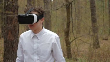 Ormanda etrafa sanal gerçeklik gözlüklü genç adam. Sevimli kız behing sevgilisi arkası çalıyor. 