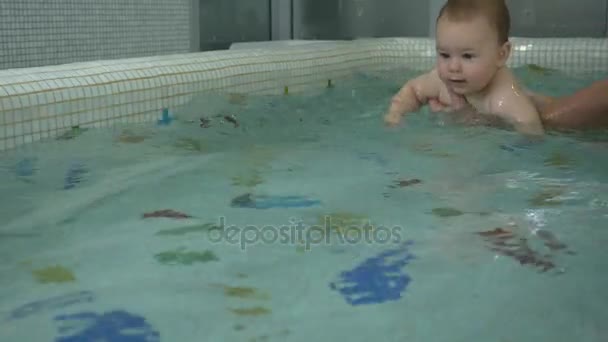 Отец учит мальчика плавать в воде — стоковое видео