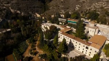 Antik Bina ve Bahçe yeşil ağaçlar, bitkiler ve dağlar, kirpik çalılar ile eski köprü kuş görünümü. Kemerler, merdiven, taş duvarlar ile bina.