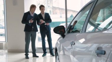 car yakınındaki elbiseli genç iş adamları