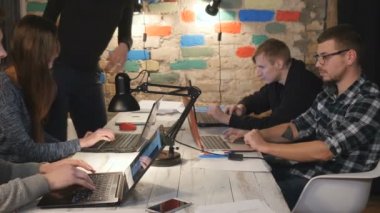 Masada oturan insanlar ve ofiste dizüstü bilgisayarlarda çalışır. iş adamları onların çalışmaları gelindi. Dizüstü bilgisayarlar ile boş işyeri kamera odaklanır.