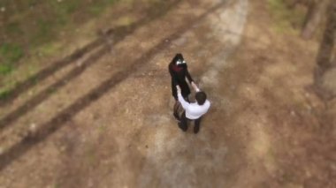 En baştan çekim. Kamera yavaş yavaş hareket ediyor. Sevgilisi ile el ele tutuşarak sanal gerçeklik gözlüklü genç kız. Gülümseyen ve etrafında dönen aşık çift. Kız ve erkek doğa üzerinde rahatlatıcı.