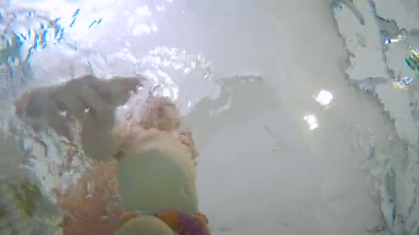 Jeune père enseignant bébé garçon nageant sous l'eau dans la piscine pour enfants. Le bébé sort de l'eau .