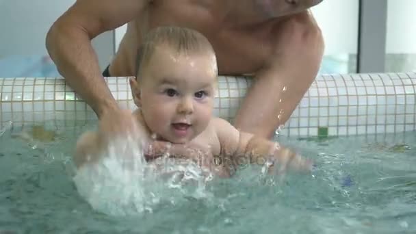 Отец обучает ребенка плаванию — стоковое видео