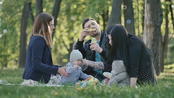 Жінки і чоловік сидять з сином — стокове відео