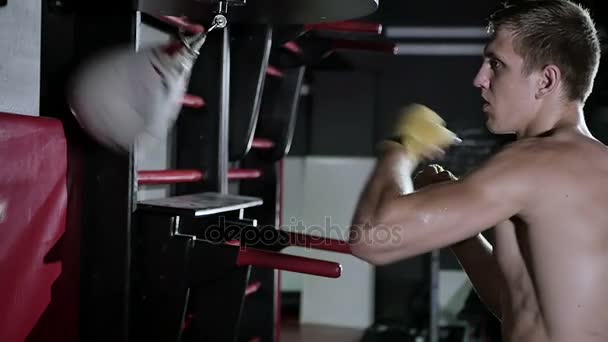 Joven hombre boxeo saco de boxeo — Vídeo de stock