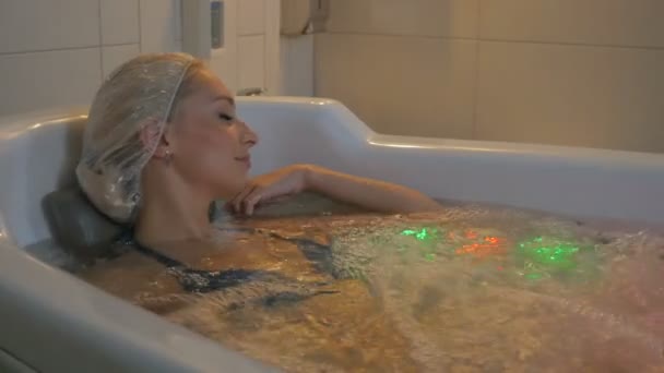Donna in cuffia doccia posa nella vasca da bagno — Video Stock