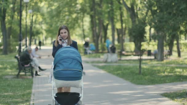 Young mother walking with pram — Stockvideo