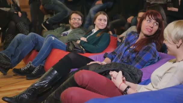 Jongeren Kijken Komische Prestaties Glimlach Mannen Vrouwen Zittend Vloer Kussens — Stockvideo