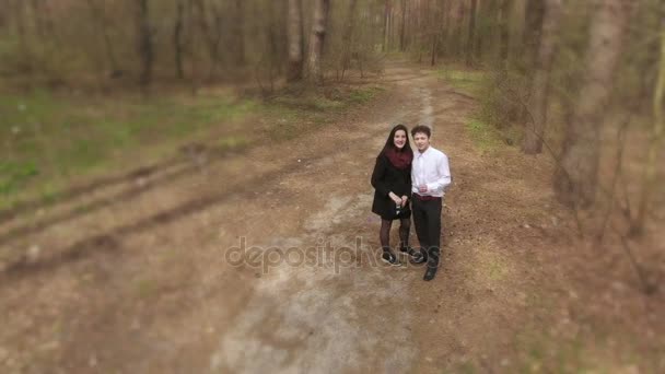 Дівчина і хлопець, що йде в лісі — стокове відео