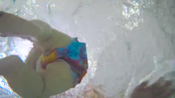 Jeune père enseignant bébé garçon nageant sous l'eau dans la piscine pour enfants. Le bébé sort de l'eau .