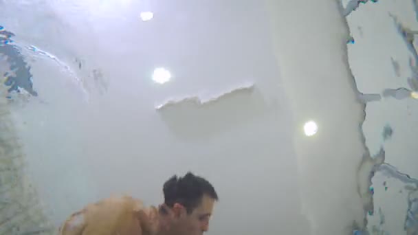 Jeune père enseignant bébé garçon nageant dans la piscine pour enfants. Le bébé sort de l'eau .