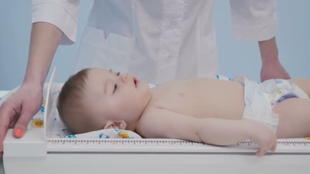 Lindo Bebé Acuesta Mesa Pañales Médico Midiendo Crecimiento Niño Adorable — Vídeos de Stock