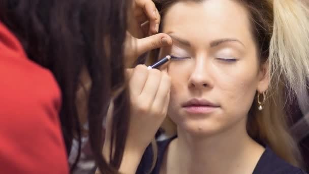 Maquiagem artista desenha mulheres olhos com lápis — Vídeo de Stock