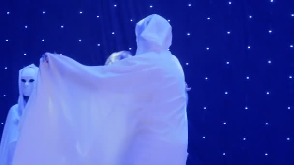 Schöne Frau tanzt mit Fremden in Mantel und Maske und singt auf der Bühne — Stockvideo