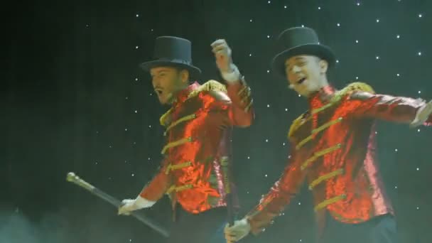 Twee stijlvolle mannen in rode staart-jassen zijn dansen en zingen op het podium in theater — Stockvideo