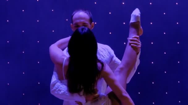 Hermosa pareja de gimnastas realiza truco en el escenario en el teatro — Vídeos de Stock