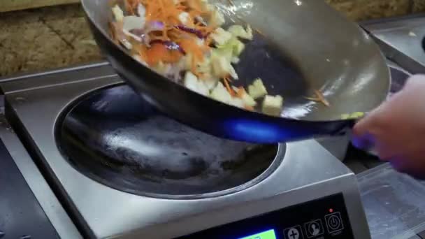 요리사는 뜨거운 팬에 튀긴된 재료를 믹스 — 비디오