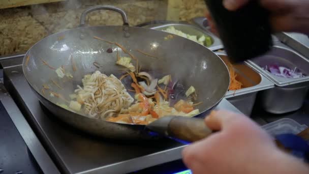 Chef verse des sauces soja et teriyaki pour udon nouilles et légumes frits dans la poêle — Video