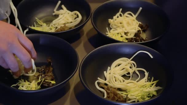 Chef-kok zetten udon noedels in de kommen — Stockvideo