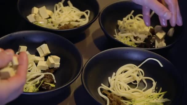 Шеф-повар добавляет тофу в миски — стоковое видео