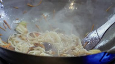Şef eklemek teriyaki ve sıcak bir tavada domates sosu için bir udon erişte