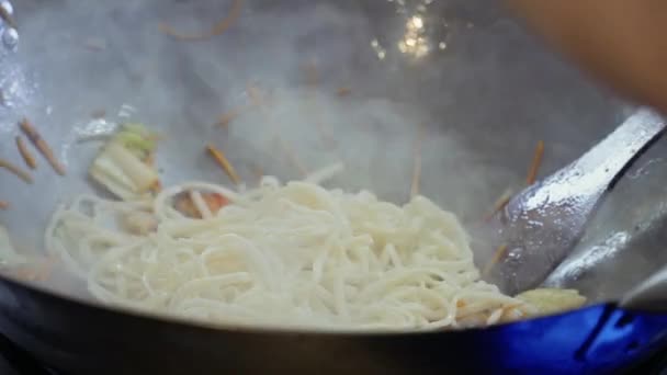 Шеф-повар положил удонскую лапшу в горячую сковороду с жареными овощами — стоковое видео