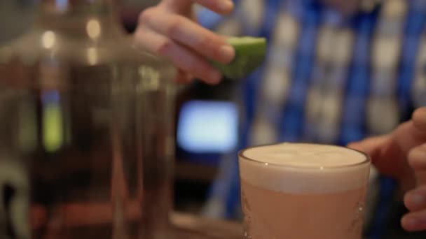 Barman décore un verre à cocktail avec une lime — Video