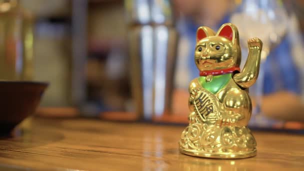 Golden fortunato maneki neko sul bancone del bar nel ristorante coreano — Video Stock