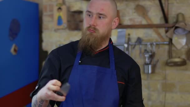 Portrait of serious chef with scars on face and with knife in hands — Stock Video