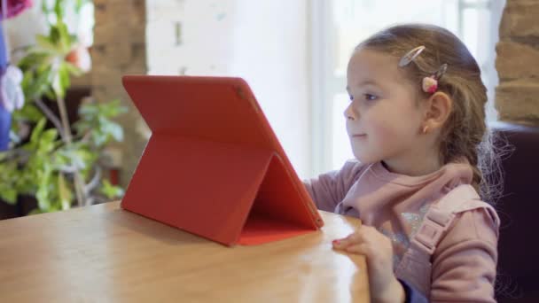 Мила дівчинка грає в ігри на цифровому планшеті — стокове відео