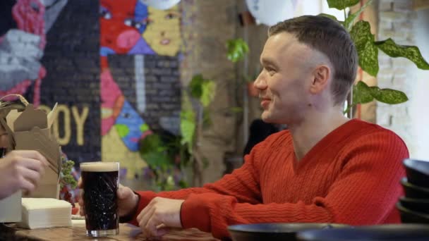 Μπάρμαν δίνει ένα ποτήρι με την μπύρα σε έναν επισκέπτη του καφέ — Αρχείο Βίντεο