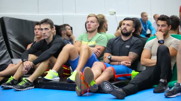 Jonge mannen luisteren een trainer op de training in de sportschool — Stockvideo