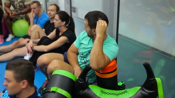 Young sport ember hallgat egy edző, a képzés az edzőteremben — Stock videók