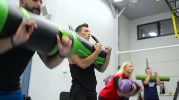 Jovens fazendo exercícios físicos com pesos no ginásio — Vídeo de Stock