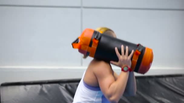 Mujer deportiva sentadillas con ponderación en el gimnasio — Vídeo de stock