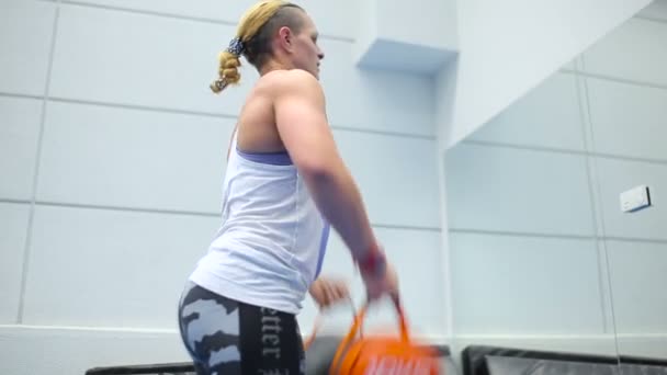 Muskulöse sportliche Frau beim Kniebeugen mit Gewichten im Fitnessstudio — Stockvideo