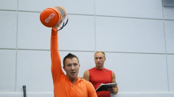运动员展示如何在健身房训练手臂的肌肉和腿部 — 图库视频影像