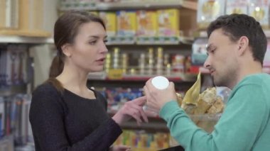 Satıcı müşteri ürünü evcil hayvan dükkanında seçmek için yardımcı olur.