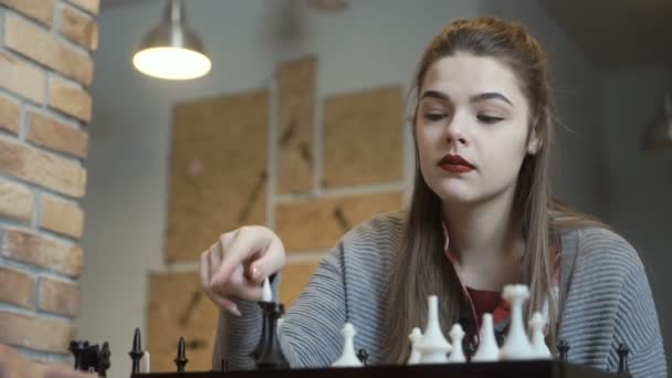 Молодая девушка признает свое поражение в шахматной игре — стоковое видео