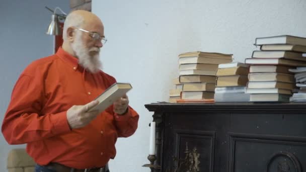 Mature man searches information in old book — Stock Video