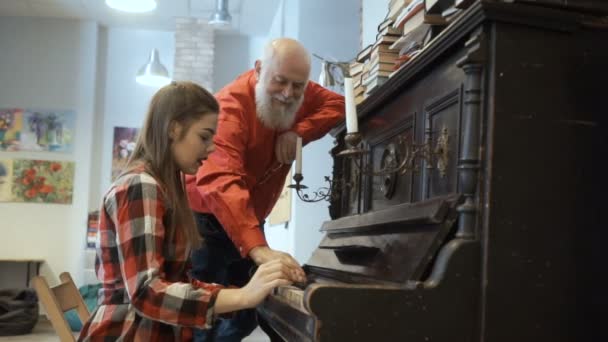 Opa luistert kleindochter speelt op piano — Stockvideo