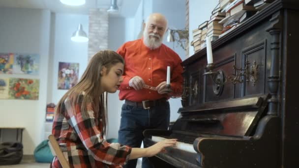 Rapariga não consegue tocar bem no piano, o avô acalma-a — Vídeo de Stock