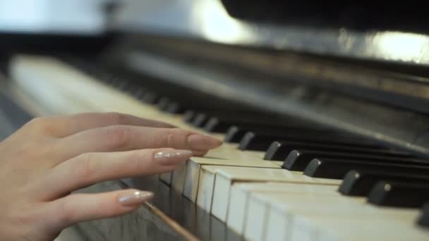 Женщина нежно касается клавиш пианино — стоковое видео